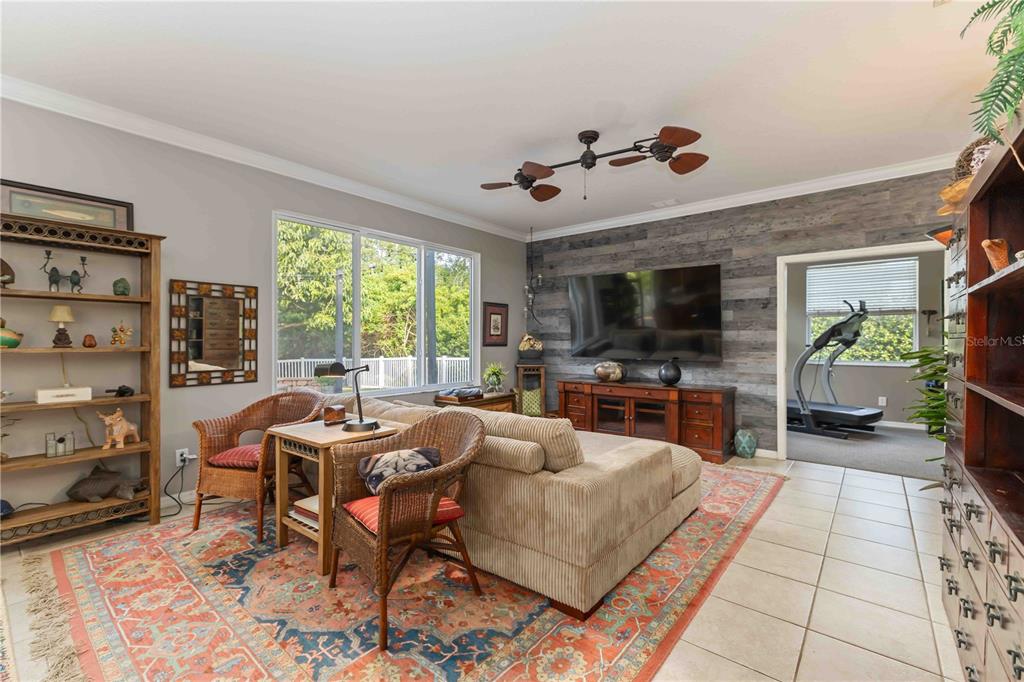 3907 62nd Terrace East Bradenton, FL 34203 - Photo 15 of 63 a living room with furniture a flat screen tv and a floor to ceiling window