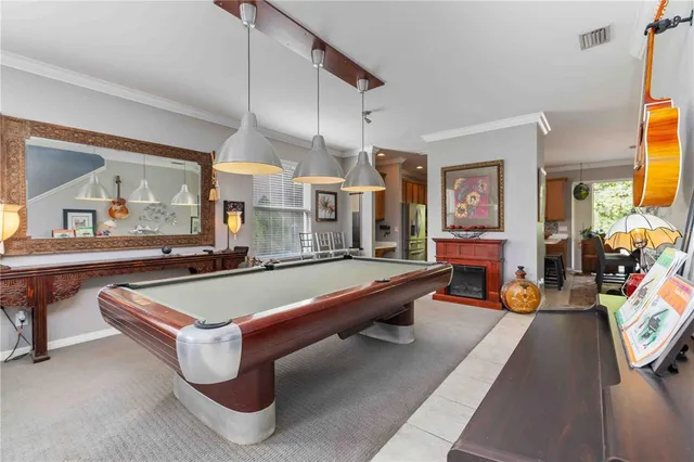 a kitchen with stainless steel appliances a stove a sink a microwave a refrigerator and white cabinets with wooden floor