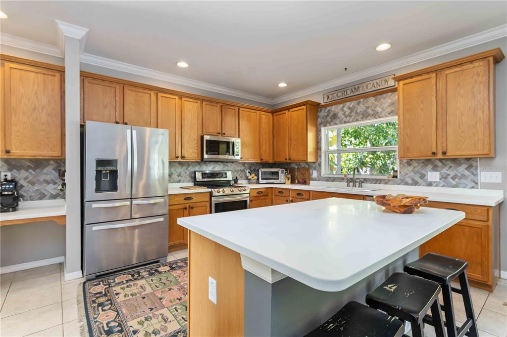 3907 62nd Terrace East Bradenton, FL 34203 - Photo 8 of 63 a kitchen with a refrigerator a stove a sink and a microwave