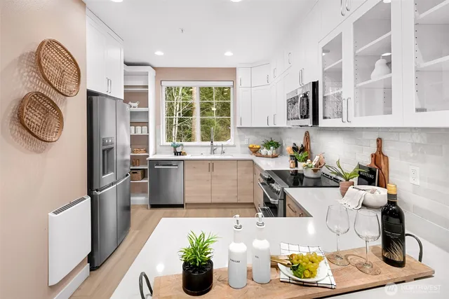 a kitchen with stainless steel appliances granite countertop a sink a stove a table and chairs