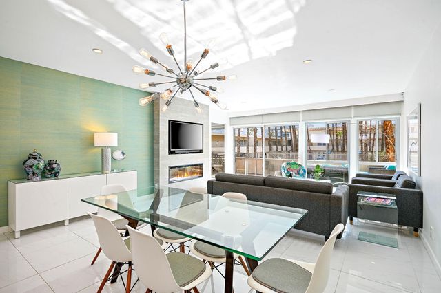 a living room with furniture a flat screen tv and a large window