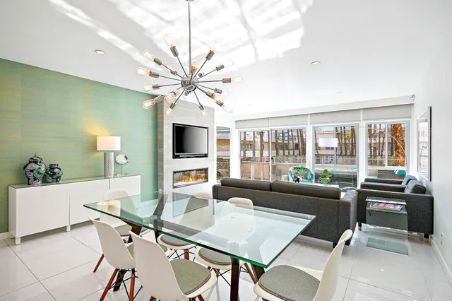 a living room with furniture a flat screen tv and a large window