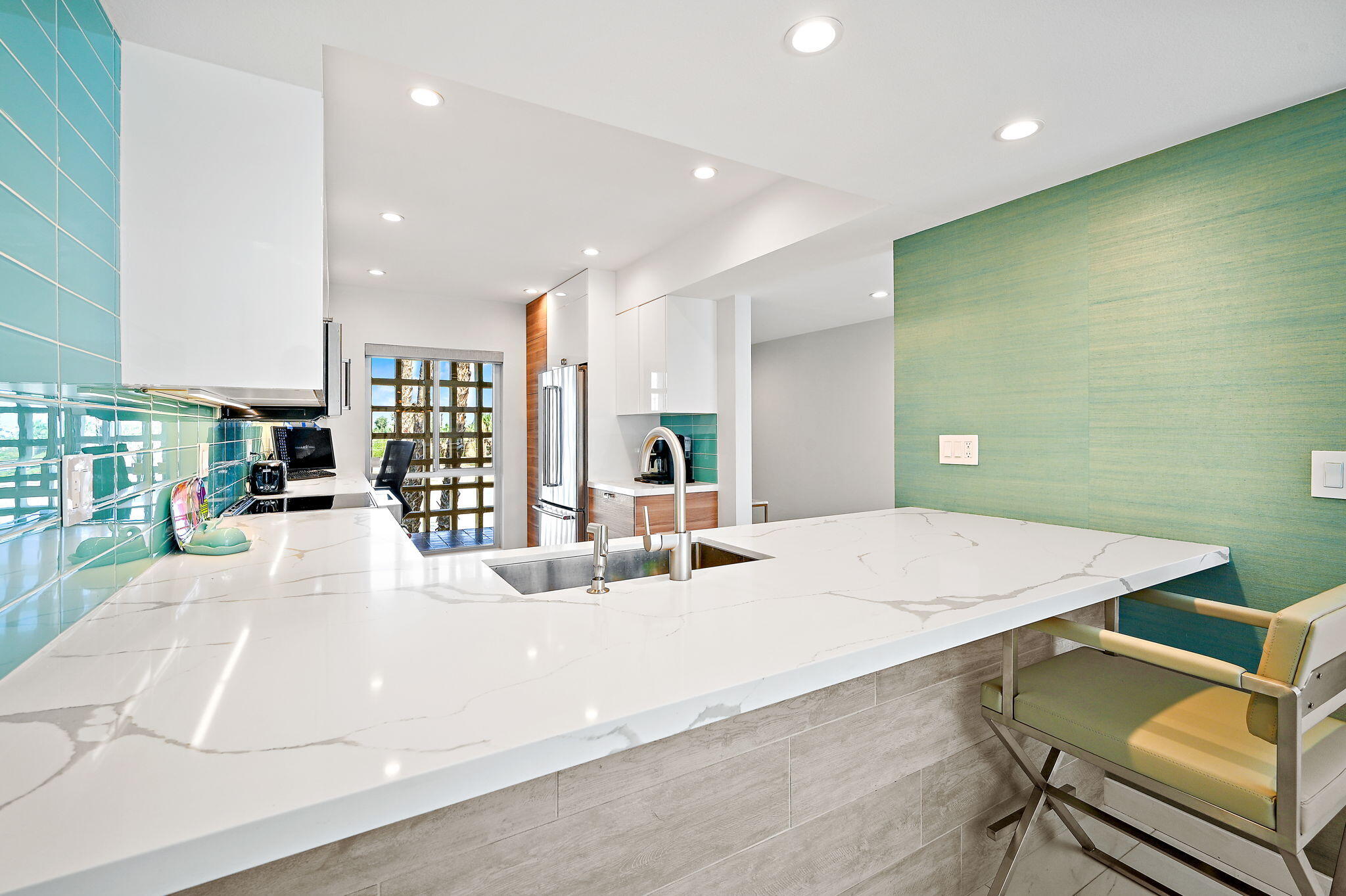 277 East Alejo Road, Unit 215 Palm Springs, CA 92262 - Photo 26 of 52 a large white kitchen with a large counter top and stainless steel appliances