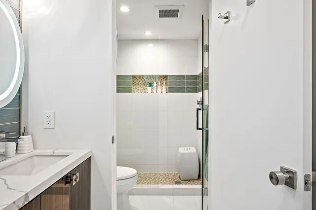 a bathroom with a double vanity sink mirror and toilet