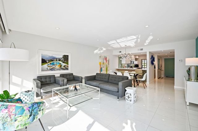 a living room with furniture and a dining table with kitchen view