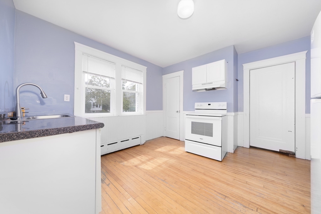 a kitchen with granite countertop a stove a sink and a microwave