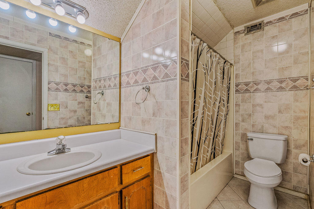 53 4th Street Shalimar, FL 32579 - Photo 30 of 47 a bathroom with a granite countertop sink toilet and shower