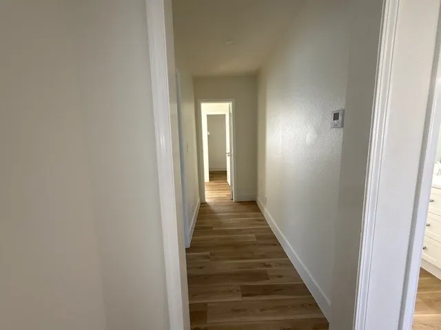 a view of a hallway with wooden floor