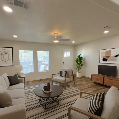 a living room with furniture and a wooden floor