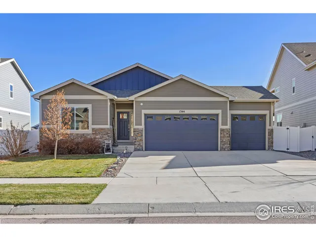 a front view of a house with a garden and yard