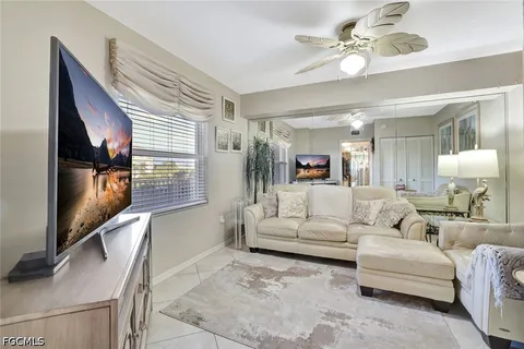 a living room with furniture and floor to ceiling windows