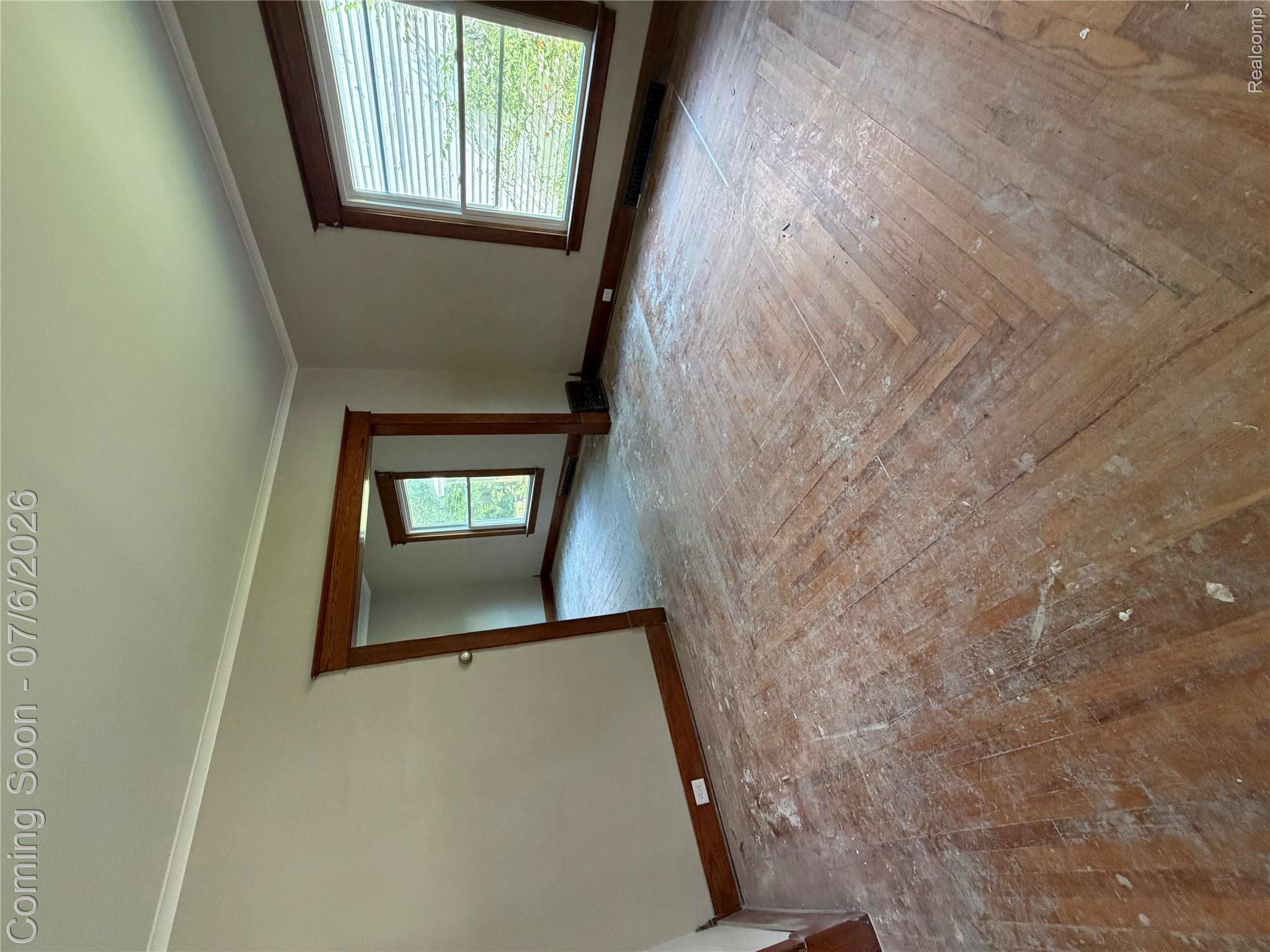 808 Division Street Owosso, MI 48867 - Photo 22 of 25 Hardwood flooring with a herringbone pattern, natural wood trim, wide baseboards, and crown molding