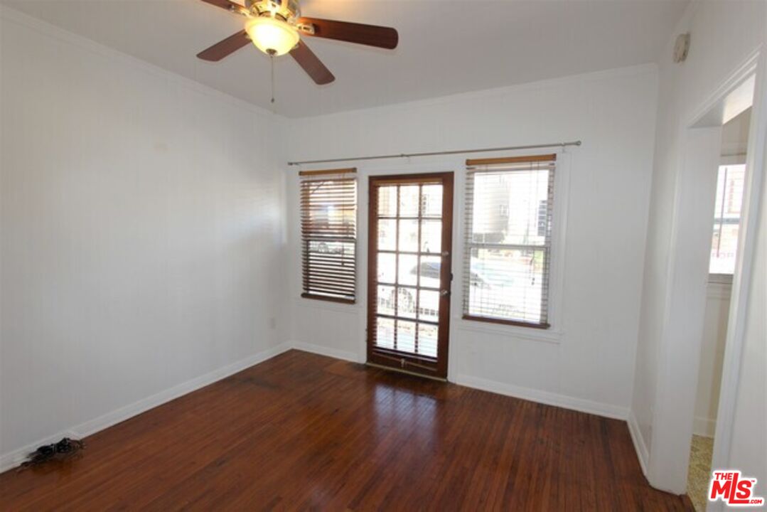 6656 Vista Del Mar, Unit A Playa del Rey, CA 90293 - Photo 3 of 16 an empty room with wooden floor chandelier fan and windows