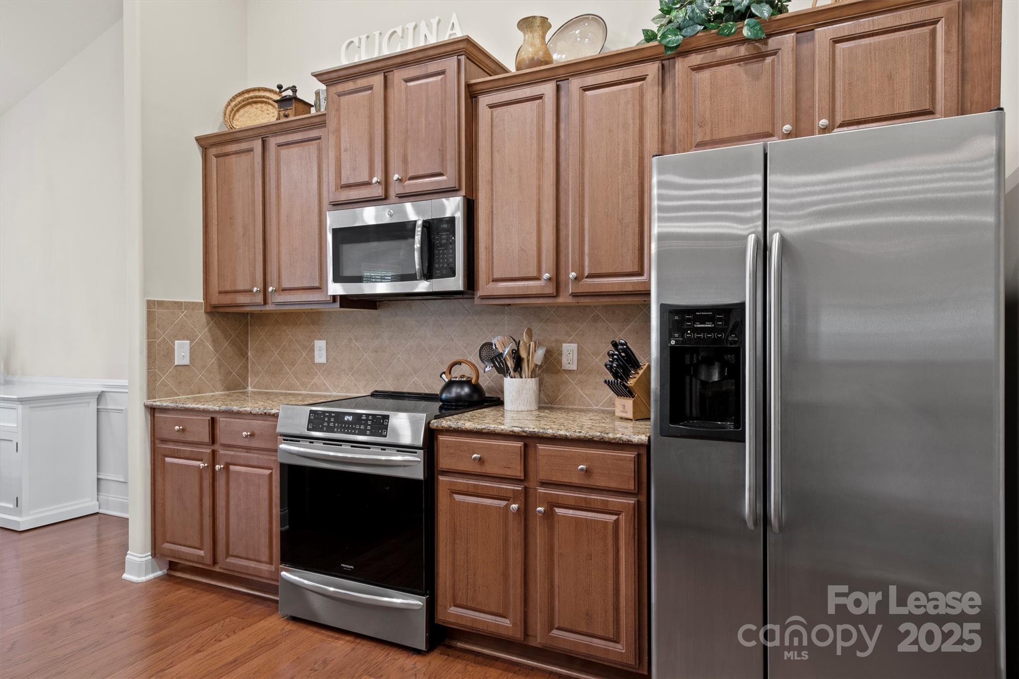 7266 Kenyon Drive Denver, NC 28037 - Photo 13 of 25 a kitchen with granite countertop a stove microwave and refrigerator