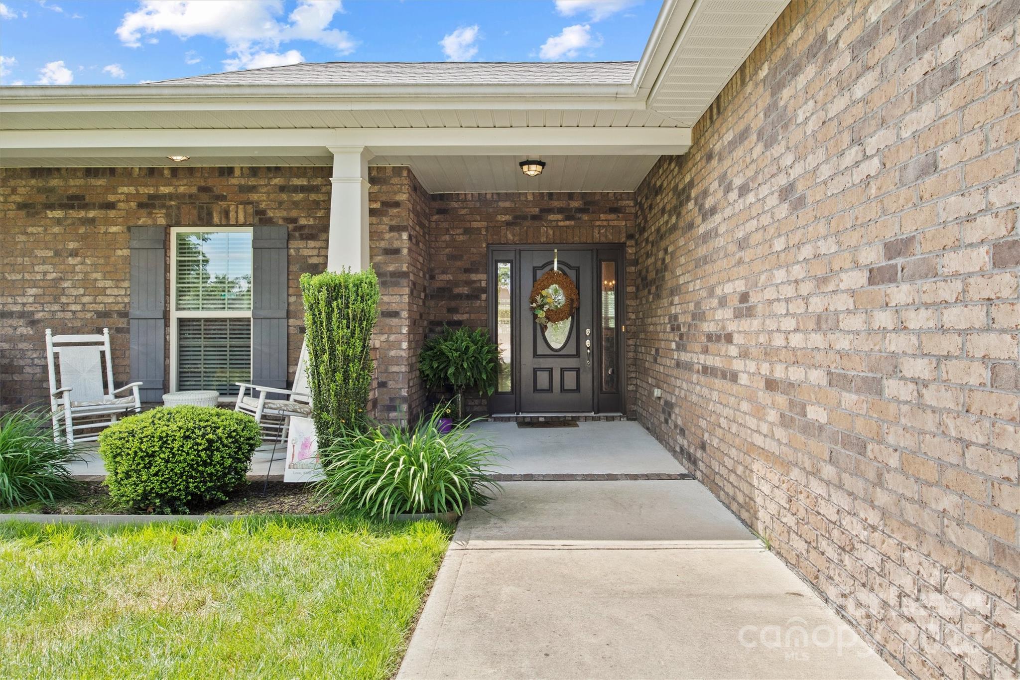 7266 Kenyon Drive Denver, NC 28037 - Photo 4 of 25 a view of entrance gate of a house with plants and garden