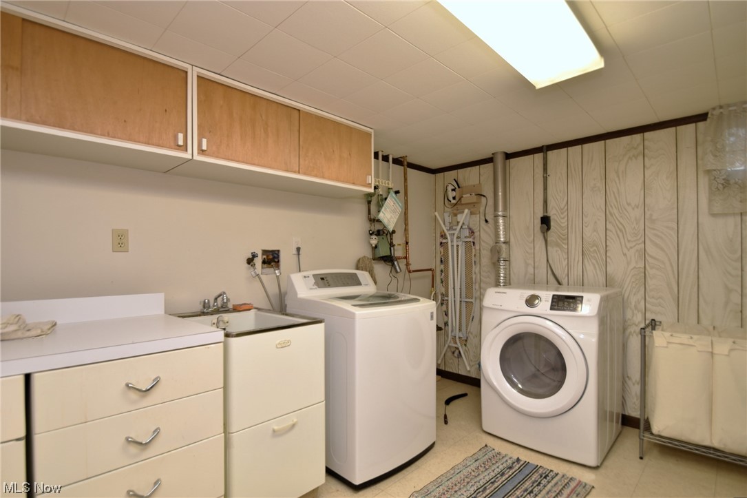 28740 Forest Road Willowick, OH 44095 - Photo 23 of 27 Laundry area with hookup for a washing machine, wood walls, cabinets, washing machine and dryer, and light tile floors