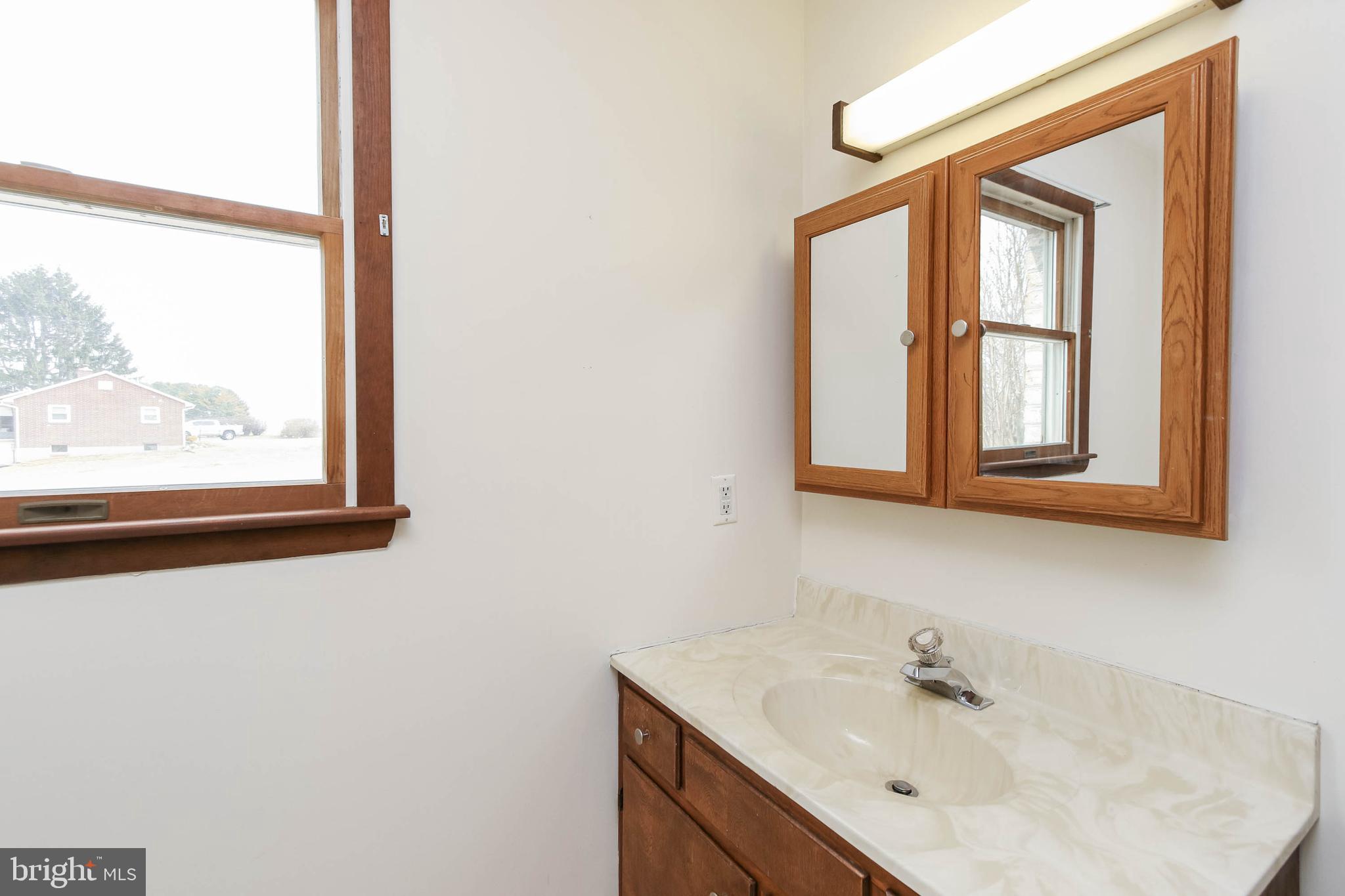 5004 Old Quarter Road Upperco, MD 21155 - Photo 42 of 61 a bathroom with a sink mirror and a window