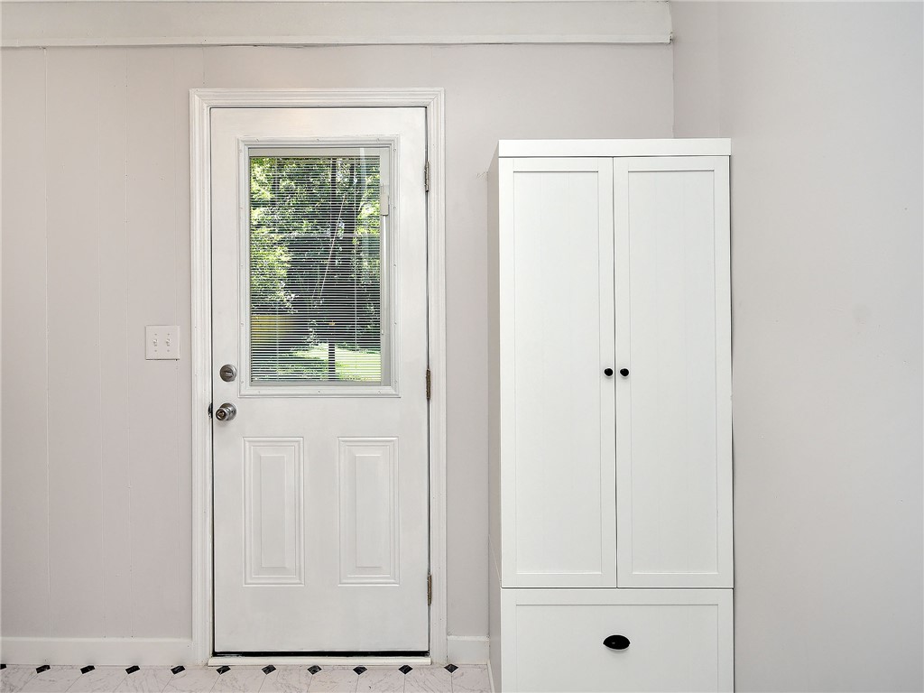 3517 Shawnee Avenue Anderson, SC 29626 - Photo 14 of 25 A classic white door with glass panels and a storage cabinet, set against light-toned walls.