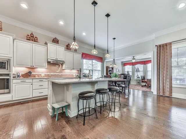 a living room with furniture a large window and a table
