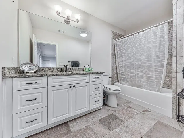 a view of a yard with plants and wooden fence