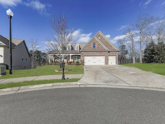 a view of a house with a big yard and large tree