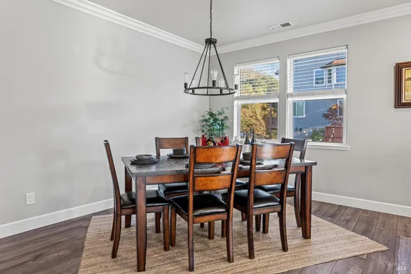 a dining room with furniture a chandelier and wooden floor