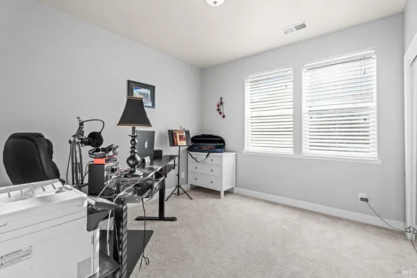a view of a workspace with furniture and a window
