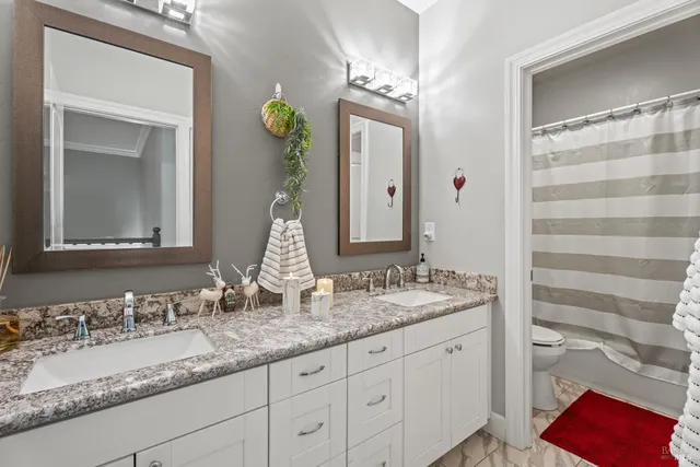 a bathroom with a granite countertop sink double and mirror