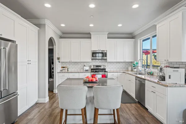 a kitchen with stainless steel appliances granite countertop a refrigerator and a stove top oven