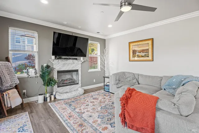 a living room with furniture a flat screen tv and a fireplace