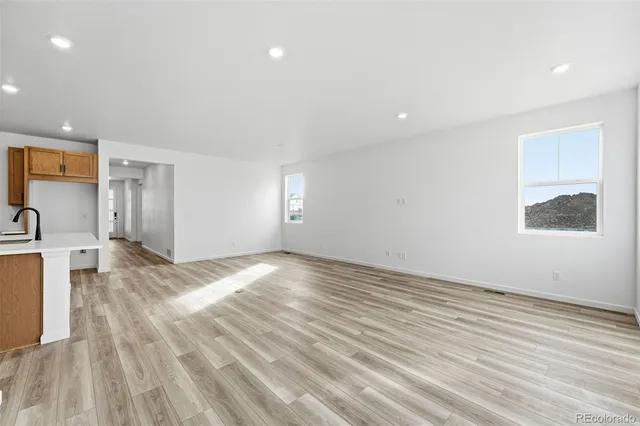 a view of a kitchen with wooden floor and a sink