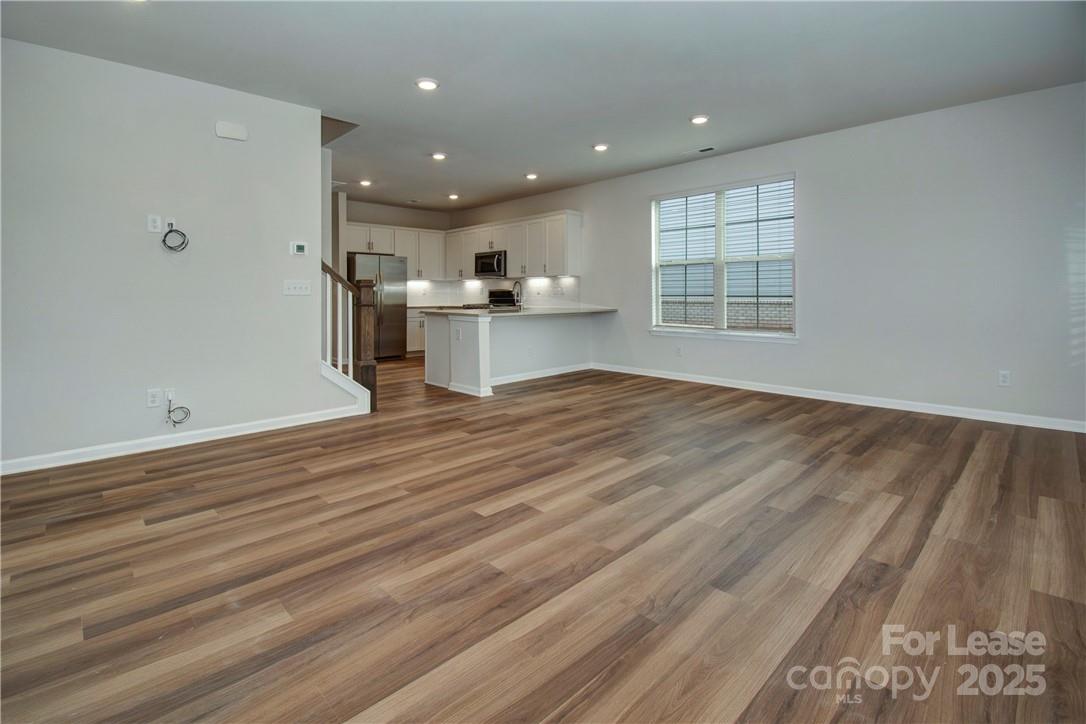 3130 Glenn Hope Way Matthews, NC 28104 - Photo 2 of 24 an empty room with wooden floor and windows