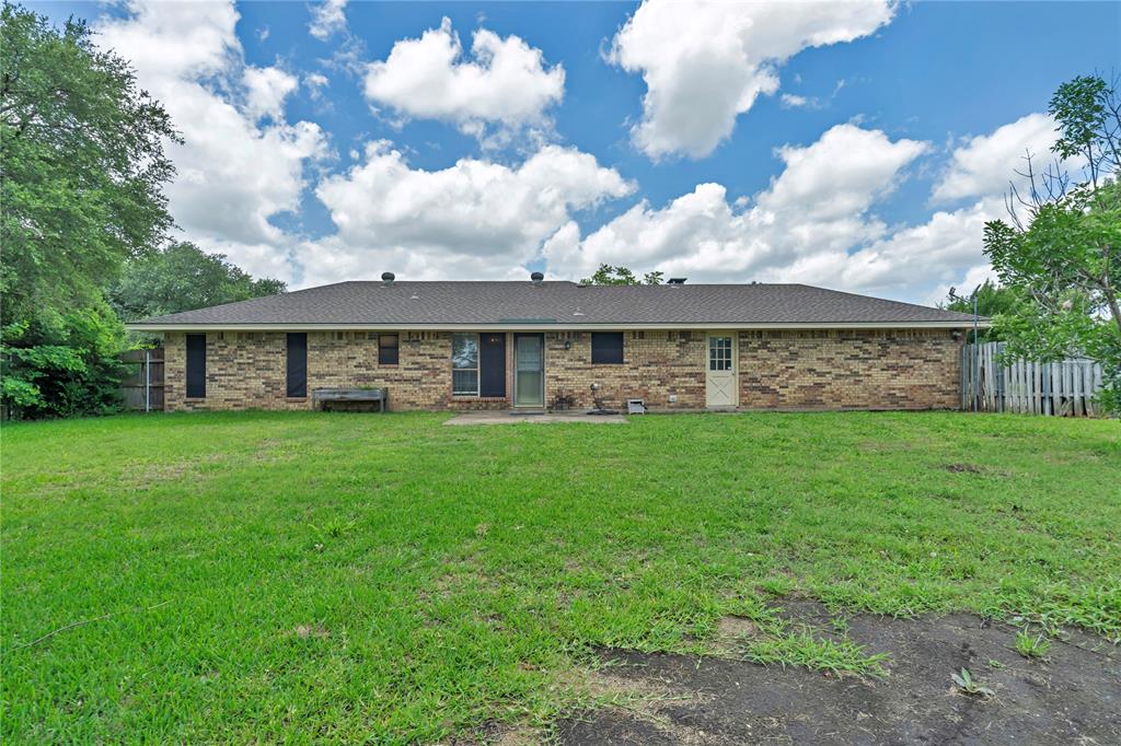 108 Prairie Creek Road Red Oak, TX 75154 - Photo 17 of 19 Expansive rear yard featuring a single-story brick exterior, a dark shingle roof, multiple egress points, and a partial wood fence