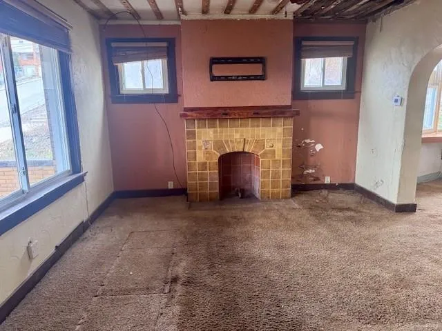a view of an empty room with a fireplace and a window