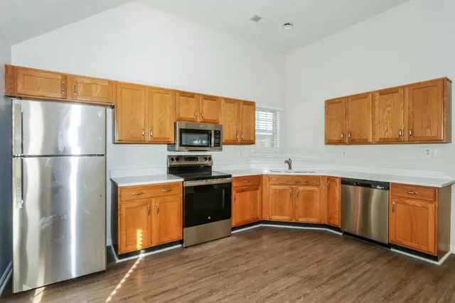 a kitchen with stainless steel appliances granite countertop a refrigerator stove top oven and sink
