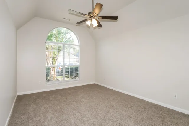 an empty room with a window and a fan