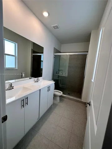 a bathroom with a double vanity sink toilet mirror and bathtub