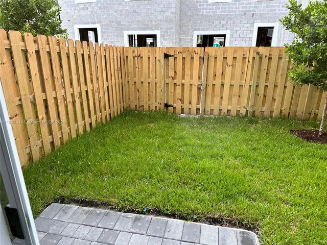 a view of a backyard with wooden fence