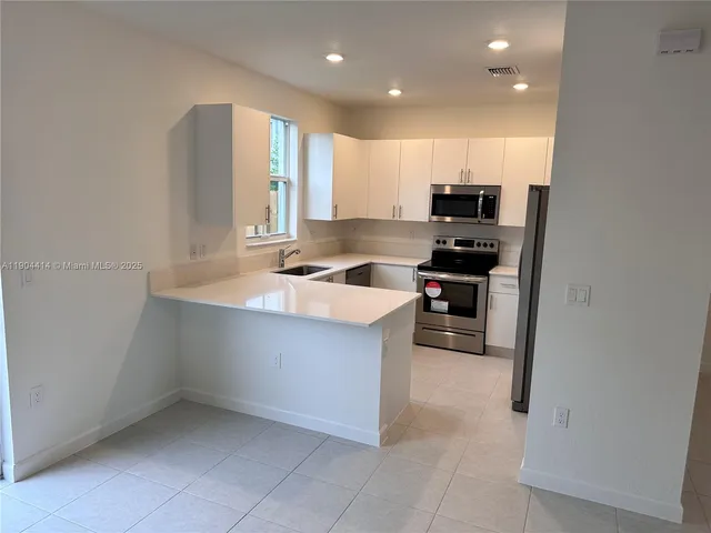 a kitchen with stainless steel appliances granite countertop a sink and cabinets