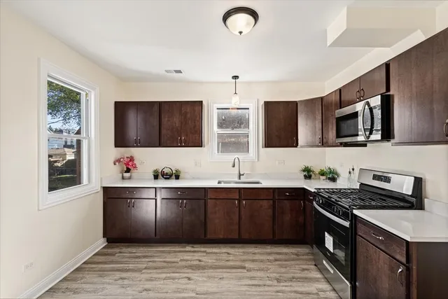 a kitchen with stainless steel appliances granite countertop a sink and a stove