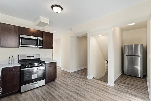 a kitchen with granite countertop a refrigerator and a stove top oven