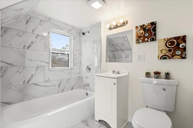 a bath room with a toilet a sink and a bath tub