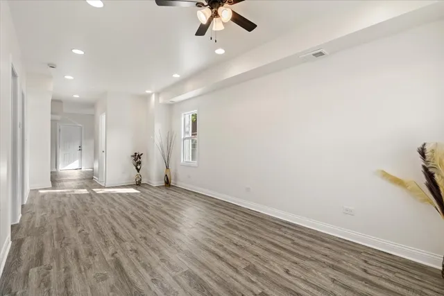 an empty room with fan and windows