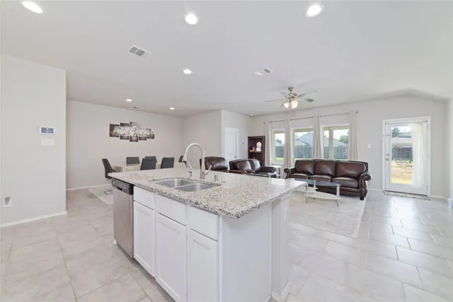 a view of kitchen island sink dining table and chairs