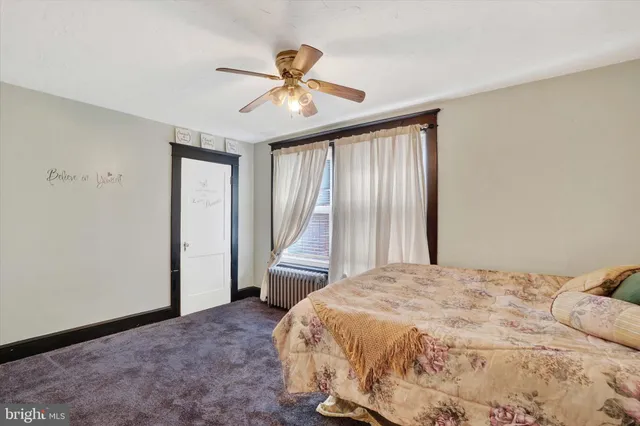 a view of a livingroom with a flat screen tv ceiling fan and a window