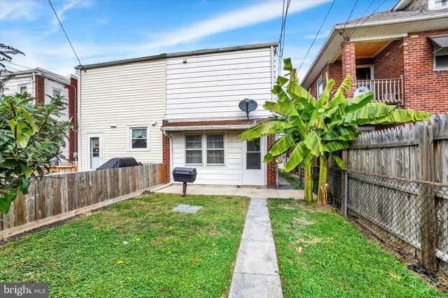 a view of a pathway of a brick house with wooden fence