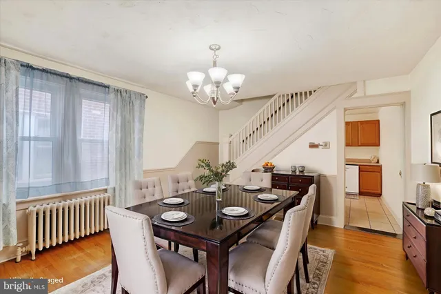 a view of a dining room with furniture a chandelier and wooden floor