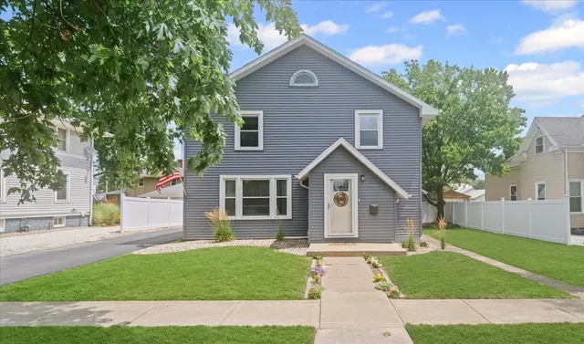 a front view of a house with a garden and yard