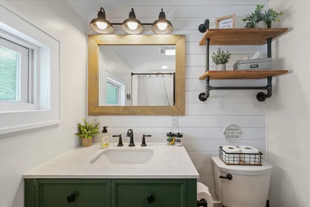 a bedroom with a bed and a flat tv screen on dresser
