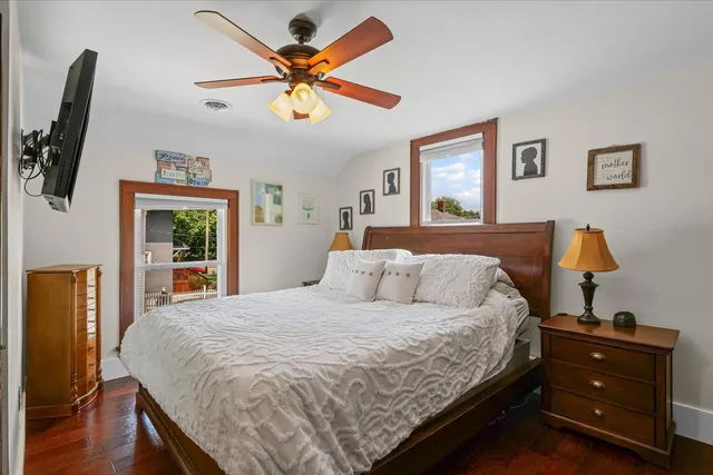 a bedroom with a bed and a flat tv screen on dresser